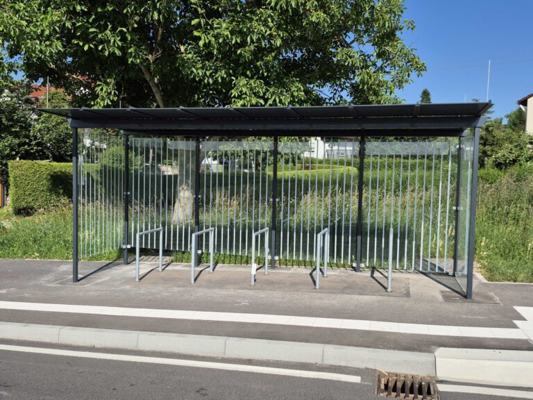 Blick auf ein verglastes Buswartehäuschen