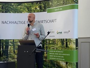 Volker Kromrey steht an einem Rednerpult und hält ein Mikrofon in der Hand.